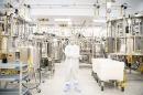 Man wearing white protective suit standing in the middle of laboratory space